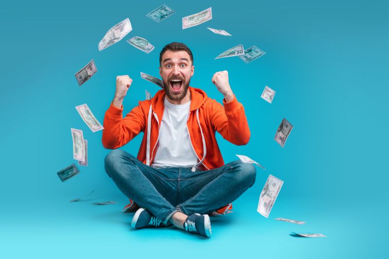 A man surrounded by falling dollar bills, smiling as he contemplates his financial windfall. The image symbolizes the excitement and reality of lottery winnings and the impact of taxes on the final payout.