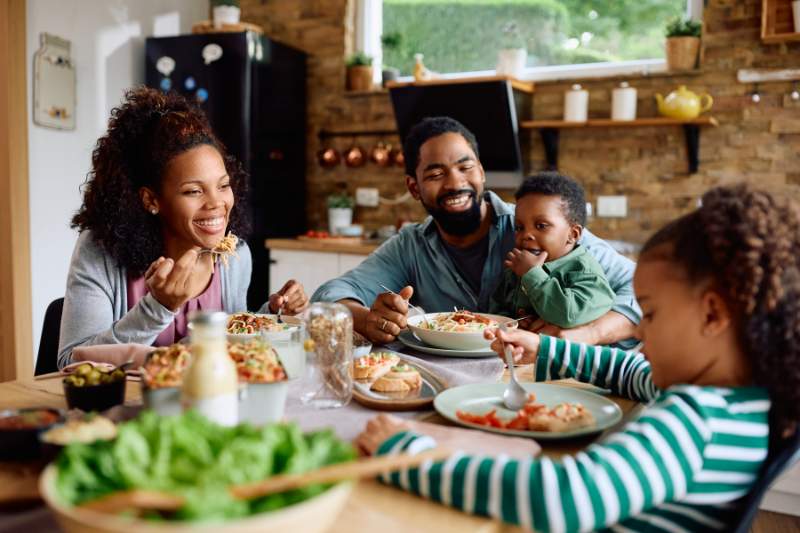 A family enjoying dinner together in their kitchen, representing the financial relief and support that the Earned Income Tax Credit (EITC) can provide to eligible families.