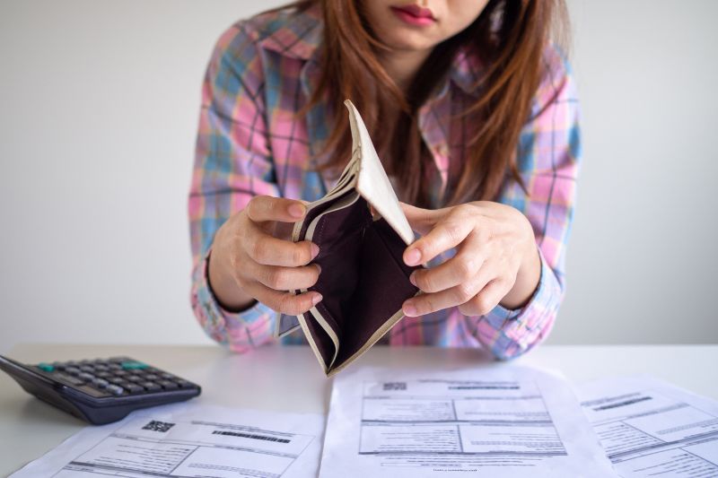 Woman holding an empty wallet, symbolizing the situation of filing taxes with no income.